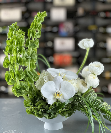 Ivory Moon Elegance arrangement with white orchids, hydrangea, ranunculus, and bells of Ireland by a Columbus, Ohio florist.