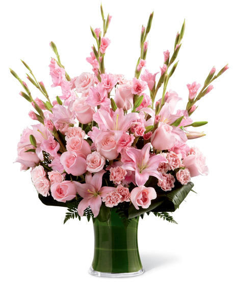 Clean vase with overflowing pink flowers such as pink gladiolas, pink roses, pink carnations, pink lilies, and mixed foliages.