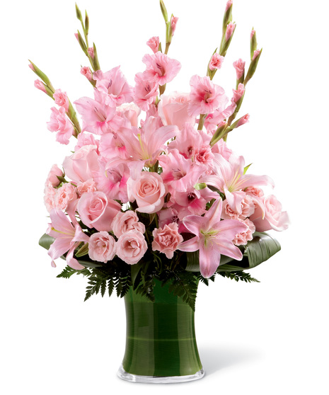 Clean vase with overflowing pink flowers such as pink gladiolas, pink roses, pink carnations, pink lilies, and mixed foliages.