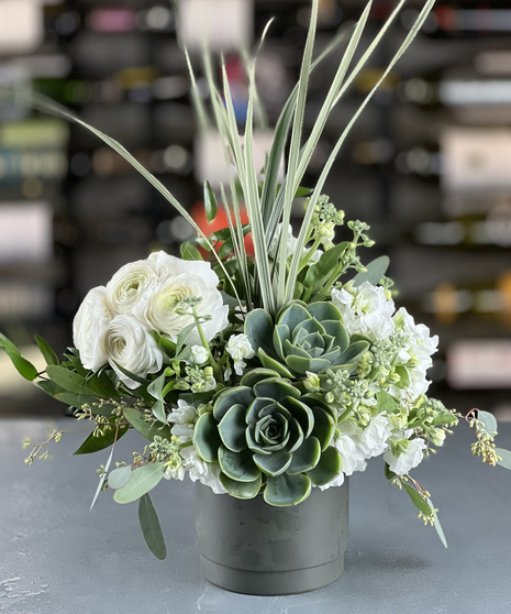 Modern succulent and white ranunculus arrangement delivered by a Columbus, Ohio florist Griffins Floral