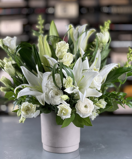 Elegant white lily and ranunculus arrangement in a modern vase delivered by a Columbus, Ohio florist Griffins Floral